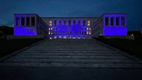 facciata università illuminata blu